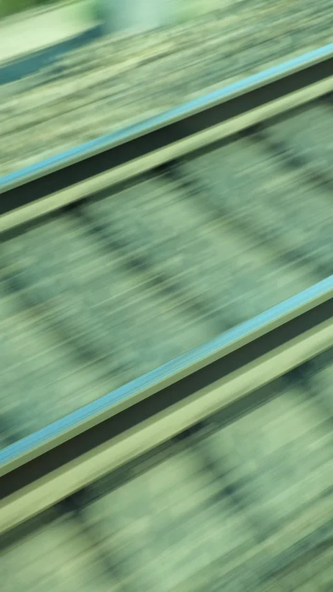 Train window view of fast moving tracks and embankment on sunny day Stock Footage 341266576
