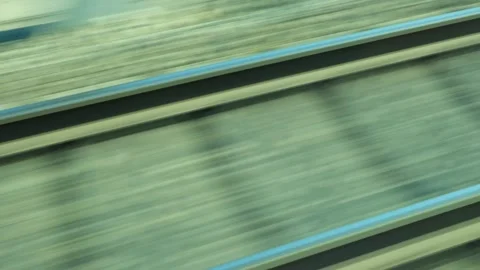 Train window view of fast moving tracks and embankment on sunny day Stockbeeldmateriaal 345658987