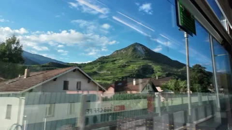 Train Window View of Industrial Area and Mountain Peaks Stock Footage 340366750