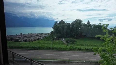 Train Window View of Lakeside Highway and Mountain Panorama Stock Footage 340367961