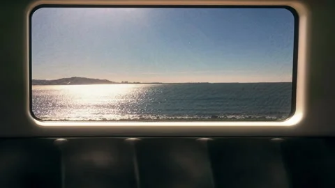 Train Window View Over Calm Ocean at Sunset Distant Coastline Stockbeeldmateriaal 318512875
