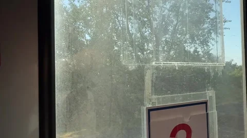 Train window view provides moving landscape perspective, revealing green forest 스톡 동영상 336189686