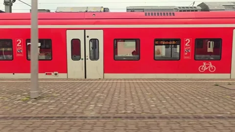 Train window view of railway platform and red train in Germany Stock Footage 344673565