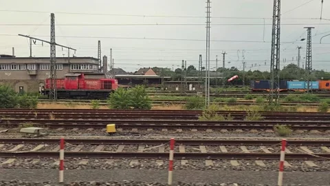 Train window view of railway station, locomotive and freight containers in .. Vídeos de archivo 344673259