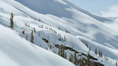Trained athlete snowboarding down the slope on snow covered mountain Stock Footage 116788544