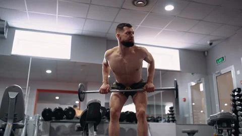 The trained bodybuilder performs deadlifts in the gym. Intense masculine energy Video stock 156480823