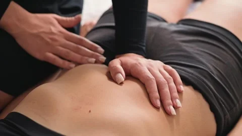 A trained manual therapist performs a specialized procedure on a person's lower Stock-Footage 344380046