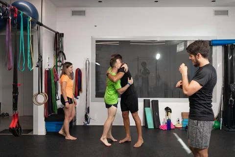 Trainee and trainer giving each other a hug at the gym Stock Photos