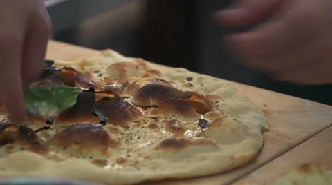 Trainee chef puts Basil leaves on Focaccia Stock Footage 68993166