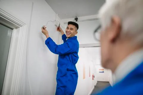 Trainee Electrician Fitting a Security Camera Stock Photos