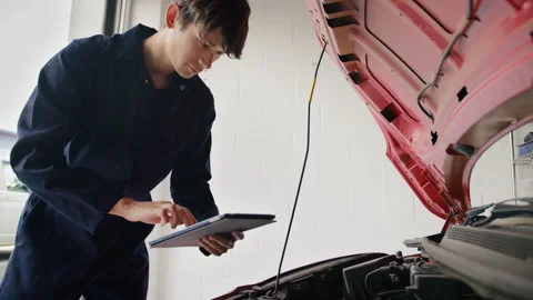 Trainee Male Car Auto Mechanic With Digital Tablet Looking Under Bonnet Of Car Stock Footage 275115053