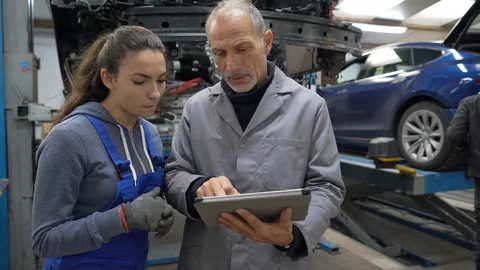 Trainee with mechanics manager working on car technology Video stock 123162784
