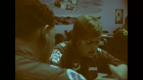 Trainee pilot talks to instructor in a study hall during pilot training - 1976 Stock Footage 103749797