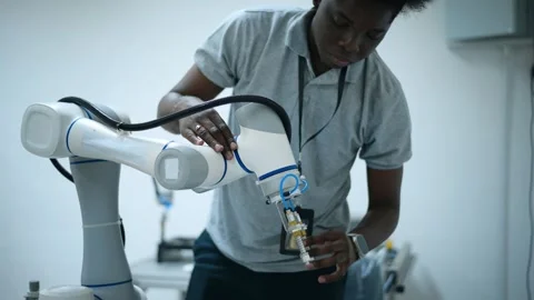 Trainee Robotics engineer learning with Programming and Manipulating Robot Ha Stock Footage 280790663