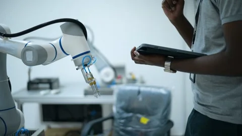 Trainee Robotics engineer learning with Programming and Manipulating Robot Ha Stock Footage 280791061
