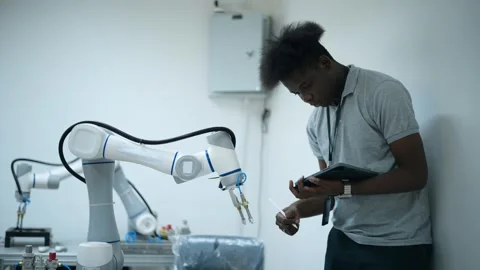 Trainee Robotics engineer learning with Programming and Manipulating Robot Ha Stock Footage 280791070