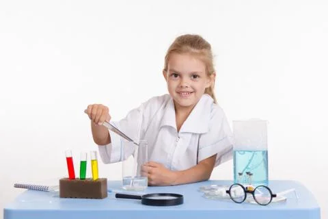 Trainee threw a piece of reagent into the flask Foto stock