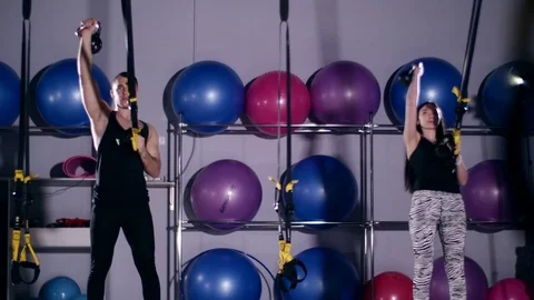 Trainees making TRX Crossing Balance Lunge Vídeos de archivo 73991122