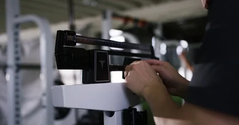 Trainer adjusting portable height measure in fitness studio Stock Footage 77333254