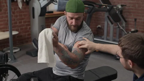 Trainer and Bodybuilder Checking Progress of Workout Stock Footage 310248945