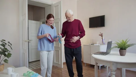 The trainer and the elderly man finish doing the exercises with a rubber band Stock Footage 173505210