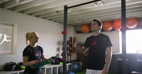 Trainer assisting man with pull-up at gym 動画素材 78201028