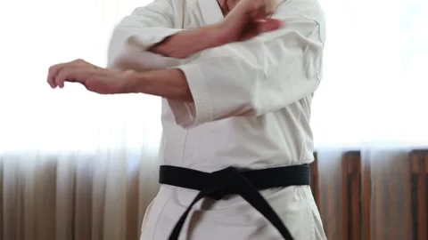 Trainer with black belt performs hand blocks Stock Footage 306538431