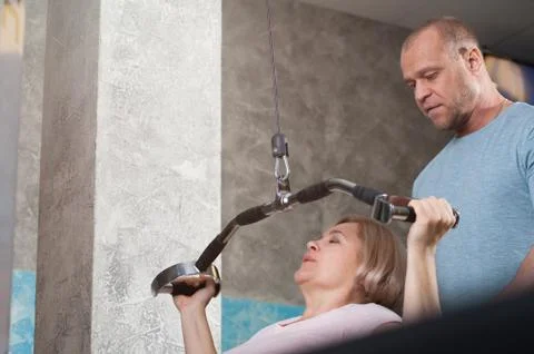 Trainer corrects the exercise of his client Stock Photos
