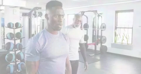 On trainer cue male trainee performing weighted walking lunges for strength in Stock Footage 334307995