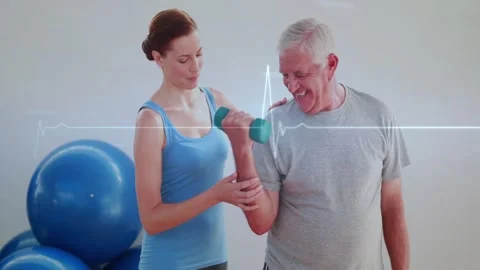 Trainer cueing client doing rehab biceps curl with green dumbbell blue balls ECG Vidéo 328233108