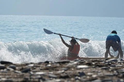 Trainer dragging a kayaker over the wave into the sea in Turkey Stock Photos