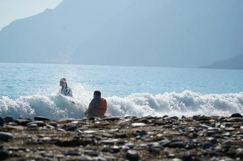 Trainer dragging a kayaker over the wave into the sea in Turkey Stock Photos