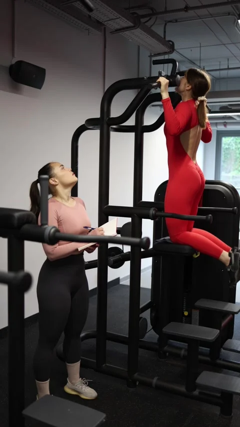 Trainer evaluates pull up progress Stock Footage 337956812