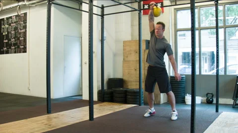 Trainer Executing Kettlebell Snatch Weightlifting Movement at a CrossFit Box Stock-Footage 40033326