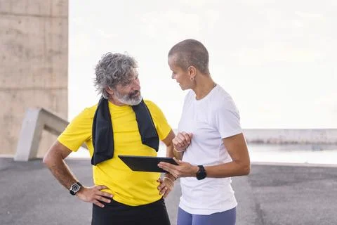 Trainer explaining training with tablet to old man Stock Photos