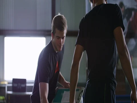 Trainer explaining while assisting the athlete to throw the ball Stock-Footage 77490954