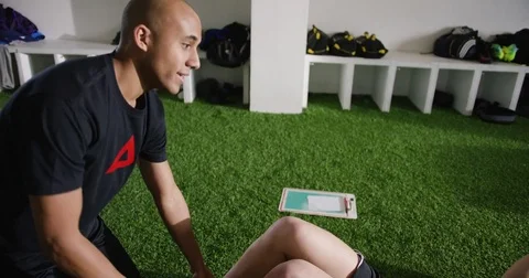 Trainer explaining to woman while doing abdominal crunches at gym 動画素材 78206644