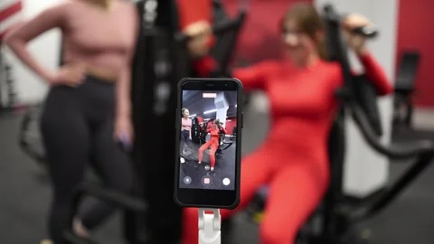 Trainer films client workout progress Stock Footage 337114607