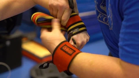 Trainer fitting wrist support to weightlifter for wounded warrior games training Stock Footage 106561693