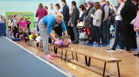 Trainer helping kids with exercises at open sport training Stock Footage 44787109