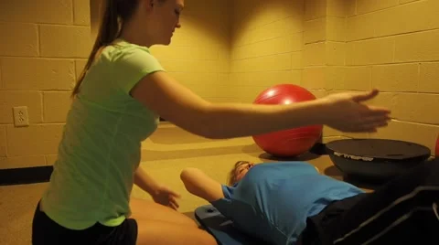 Trainer helping a person exercise Stock Footage 45519482