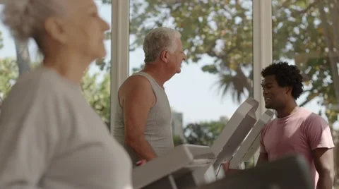 Trainer helping senior man exercising in wellness club Stock Footage 11144310