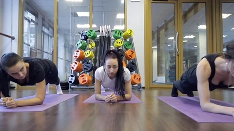 Trainer with her group of women do exercise based on plank in studio Video stock 74078984
