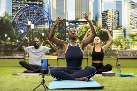 Trainer leading mindful breathing exercise on yoga mat while filming Fotos Stock