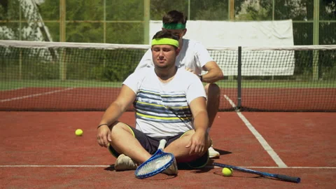 Trainer massaging shoulders of plump tennis player Stock Footage