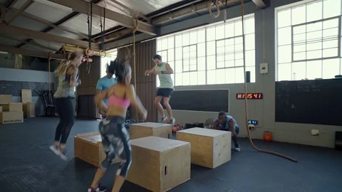 Trainer motivating class doing box jumps Stock Footage 71618464