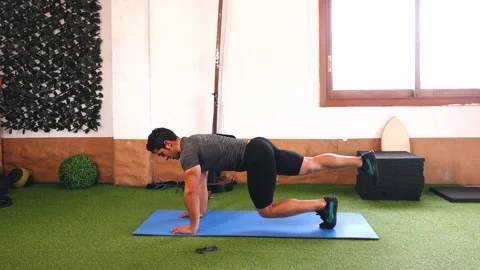 Trainer performing functional exercise working the core on blue mat Video stock 149655630