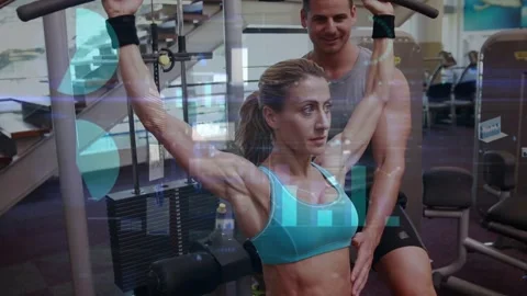 Trainer placing hand, client pulling lat pulldown bar in gym, guiding form with Stock Footage 333368790