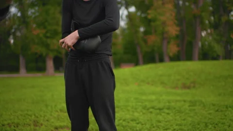 Trainer securing equipment, Closeup of instructor fixing gloves outdoors, Coach Stock Footage 325031517