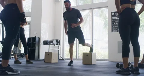 Trainer showing athletes how to preform an exercise Stock Footage 96984095